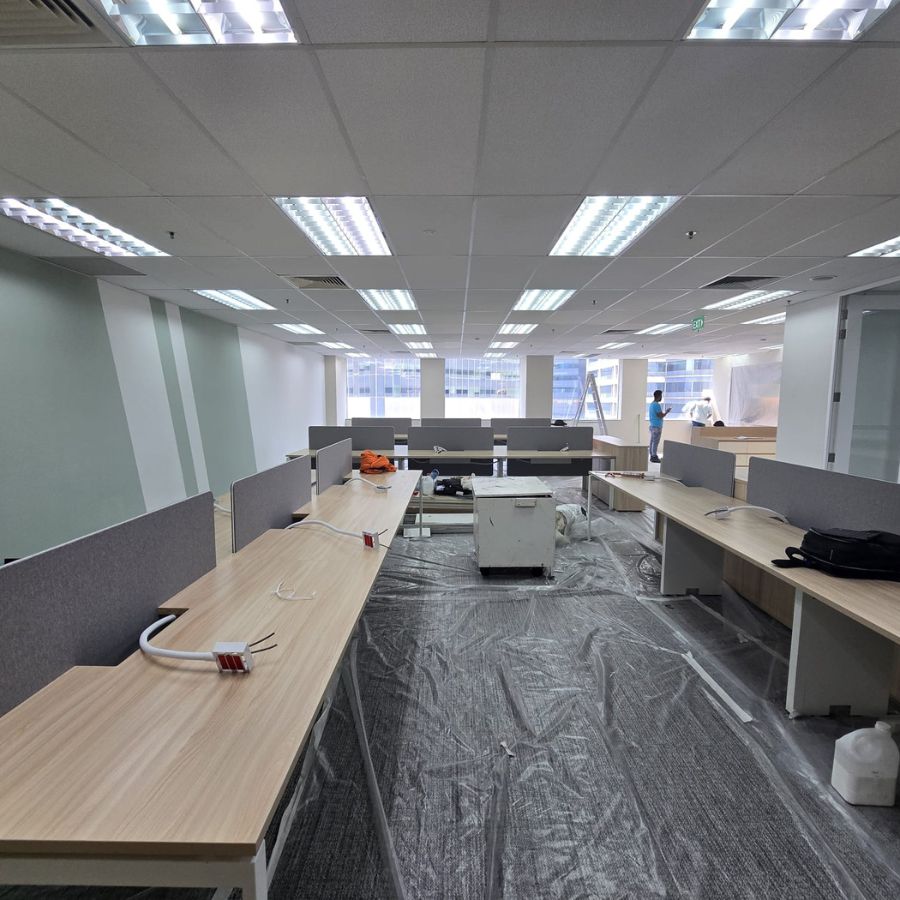 Bright office space with custom-built workstations being installed, highlighting clean layouts and carpentry work in progress