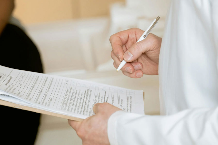 A close-up of hands holding documents, symbolizing the coordination process to ensure approvals and compliance.